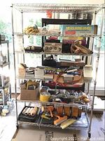 Full view of the metal Metro shelving unit loaded with tools and boxes to show shelving structure and size
