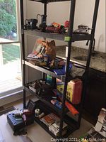 Four-tier plastic shelving displaying various tools; top shelf holds two corded angle grinders/polishers and an air sander.