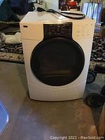 Full frontal view of Kenmore Elite HE3 dryer showing door and top surface in basement setting.