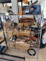 Full view of the metal wire shelving unit holding various tools and items (not included in lot) with clear view of paint splatters and structural details