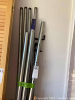 Metal pipe clamps bundled upright with visible tags and labels