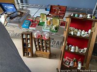 Wide shot showing thimbles in original boxes and wooden display cabinets, manicure set, polished stone and robe tie on shelves
