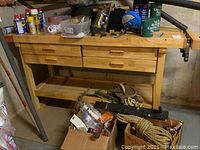 Front view of work bench showing butcher block top, four drawers, bottom shelf, and assorted items removed prior to pickup