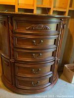 Front view of curved chest showing five drawers and side cabinets