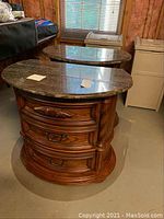 Front view of two matching wooden nightstands side by side on concrete floor under basement window