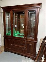 Full front view of two-piece china cabinet showing three leaded glass doors, lower drawers and side cabinets
