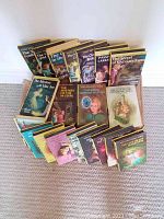Twenty Nancy Drew hardcover books arranged on carpet with spines and covers visible.