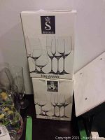 Two unopened boxes of Spiegelau Vino Grande wine glasses stacked with visible branding and product images on the boxes.