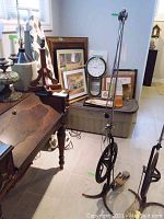 Full view of the tall antique dentist tool alongside furniture and framed items, showing the overall height and structure.