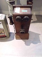 Front view of wooden telephone showing twin bells and mouthpiece
