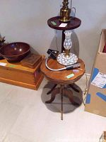 Two wooden tables shown side by side - one wooden pedestal tripod table with claw feet and a smaller tray-style table with brass base