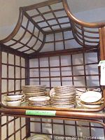 Multiple stacks of plates, cups, saucers displayed on shelving