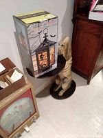 Dog shaped table holding the boxed Halloween lantern, showing side view and scale.