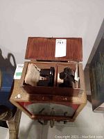 Top view of open cardboard box containing two View-Master stereoscope viewers and reels with an auction tag