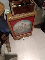 Front view of game showing housing, glass lithograph and levers