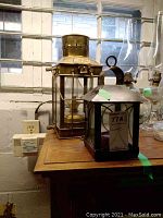 Two lanterns on wooden surface near window