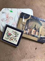Three sets of placemats pictured: floral Aynsley Pembroke, wine bottle Pimpernel design, and another floral set in pastel colors.