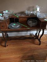 Front view of wood desk secretary displaying drawers, pigeon holes, and glass bowls on top (contents not included)