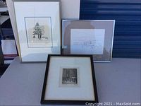 Three framed art prints arranged on a flat surface showing varying frame styles and sizes.