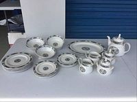 Full set arranged on table showing plates, bowls, platter, teapot, creamer, and sugar bowl.