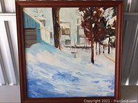 Full view of framed painting showing snowy street with trees and houses under snow.