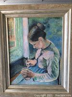 Full view of framed painting showing woman sewing, with natural window backdrop.