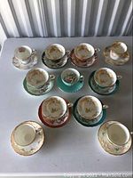 Overhead view of nine teacups on matching saucers plus two additional saucers laid out on table