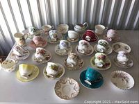 Overview of 20 teacup and saucer sets arranged in rows