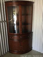 Front view of full curio cabinet showing glass doors and lower storage