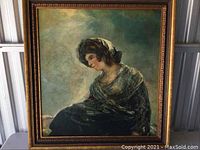 Full view of the framed portrait showing a woman seated in profile, wearing a dark dress and head covering, with ornamental wooden frame.