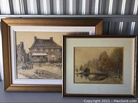 Two framed artworks placed side by side showing a vintage rural scene and a lakeside landscape with trees.