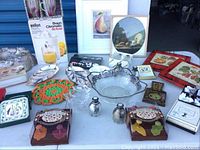 Photo of various miscellaneous decor and kitchen items including framed prints, decorative bowl, trays, salt and pepper shakers, kitchen accessories