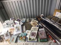 Tabletop view showing a wide variety of cards and other printed materials in assorted sizes and art styles along with several umbrellas to the right of the table