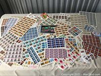 Overview of assorted Canadian postage stamp sheets spread on table