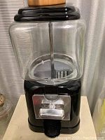 Front view of the 12 inch candy dispenser with clear glass container and black base