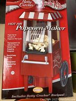 Front box view showing product name, brand and a picture of the popcorn maker with popcorn popping inside.