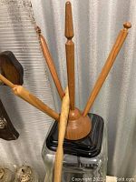 Seven wooden calligraphy pen holders are arranged with their handles upward. They show various natural wood grains and finishes, all finely turned and polished.