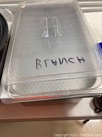 Clear plastic lid labeled 'BRUNCH' sitting on top of a fryer bin