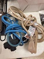 Photo showing two coiled power cords, one beige and one blue, each with multi-outlet extension blocks on a white surface.