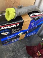 Side view of Simoniz branded box with green/yellow brush attachment on top.
