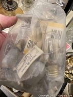 Plastic bag with Singer replacement light bulbs and other small sewing machine parts