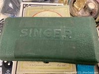 Green textured plastic case embossed with Singer on lid