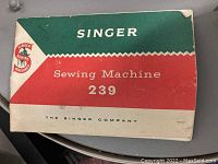 Front cover of Singer Sewing Machine Manual model 239 in green, red, and white color scheme with the Singer logo.