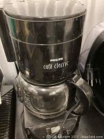 Philips Café Classic coffee maker showing full unit with black plastic body and glass carafe.