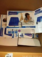 Three Aerobed ExtraBed Twin air beds in unopened boxes stacked side by side.