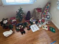 Wide view showing most Christmas items including gift bags, wrapping paper rolls, bows, candles, dish towels, Santa figure, small trees.