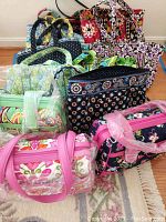 All nine Vera Bradley quilted cotton items arranged on floor