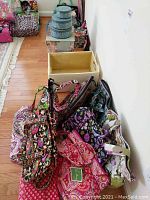 Multiple patterned Vera Bradley handbags and an empty woven basket