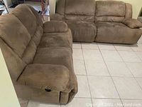 Side view of two brown suede recliners showing their condition and size.