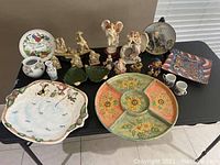Photo showing the full lot of porcelain figures, plates and trays arranged on a table
